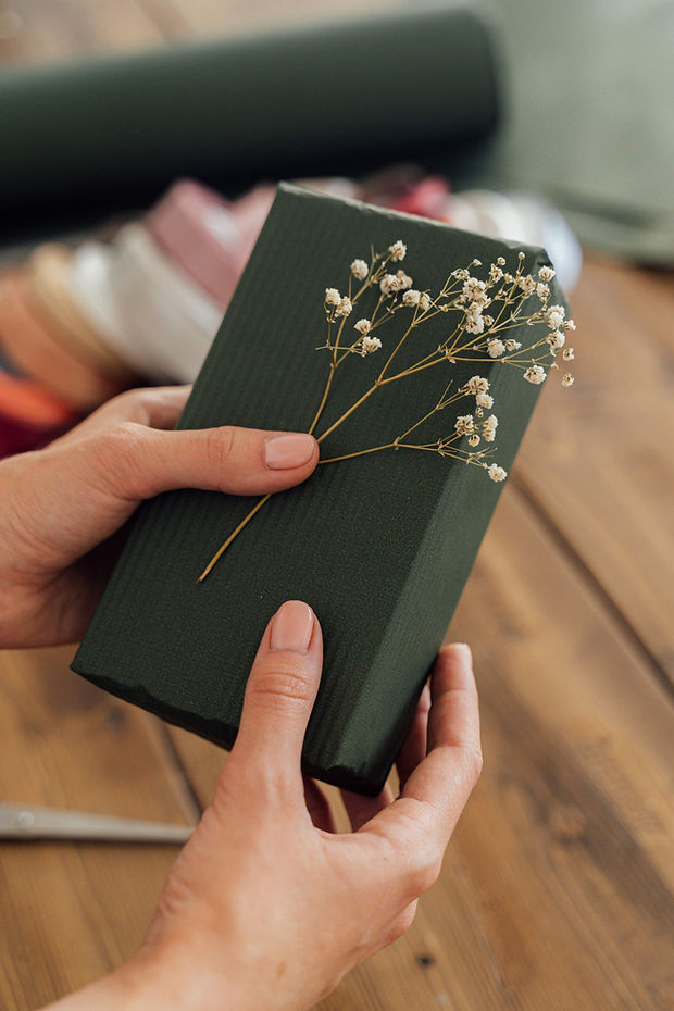 Single book in green wrapping and with flower being prepped for shipping. 