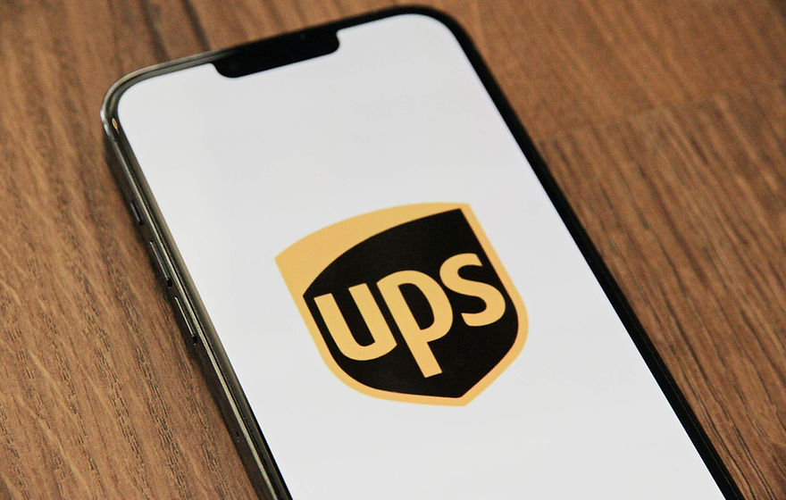 Black and yellow UPS symbol on smartphone screen with white background.